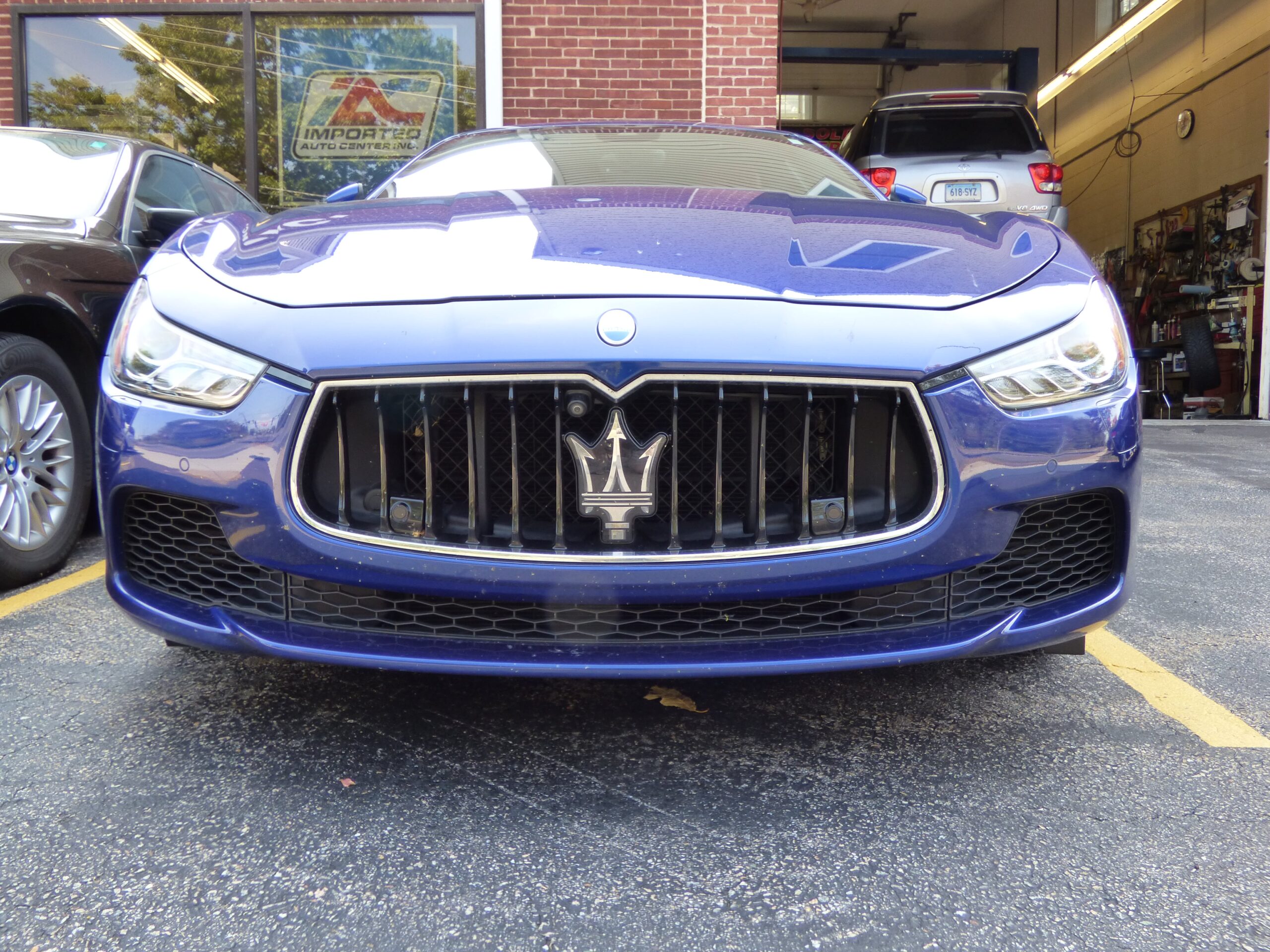 Blue Maserati parked in front of imported auto center